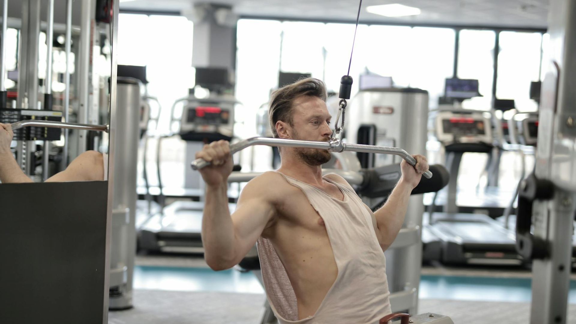 Man performing strength exercises in a minimalist industrial gym environment